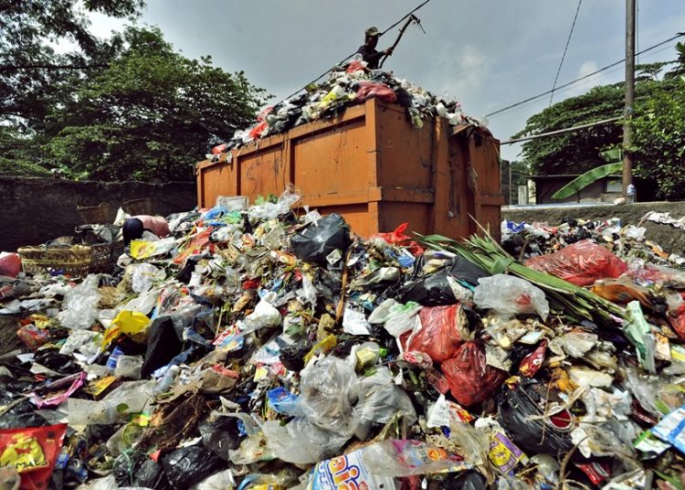JAKARTA, 3/2 - VOLUME SAMPAH JAKARTA. Petugas menaikkan sampah ke dalam bak truk di Tempat Pembuangan Sementara Cipinang, Jakarta Timur, Minggu (3/2). Usai banjir besar Jakarta pertengahan Januari 2013, volume sampah di seluruh wilayah meningkat rata-rata 1100 ton per hari, terbesar dari Jakarta Utara dan Barat. FOTO ANTARA/Yudhi Mahatma/Koz/pd/13.