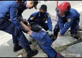 Demi Selamatkan Ponsel Warga, Anggota Damkar Jakbar Rela Masuk Got Sempit