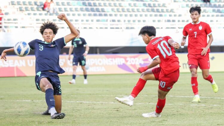 Pemain Thailand U-19 Thanakrit Chotmuangpak (tengah) berusaha menendang bola ke arah gawang Australia pada babak semifinal ASEAN U-19 Boys Championship di Stadion GBT Surabaya, Sabtu (27/7/2024) sore. ANTARA FOTO/Rizal Hanafi