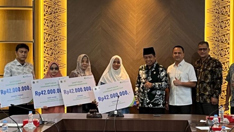 Ketua DPRD DKI Jakarta Khoirudin (ketiga kanan) secara simbolis menyerahkan santunan Jaminan Kematian dari BPJS Ketenagakerjaan di Jakarta, Rabu (8/1/2025). ANTARA/Ho-DPRD
