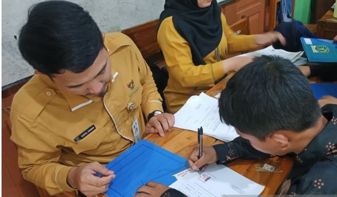 Petugas saat memberikan ijazah kepada seorang siswa pada program pemutihan ijazah di Jakarta, Selasa (3/6/2025).