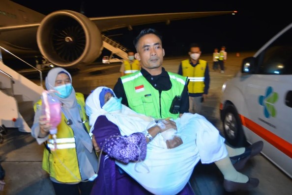 Petugas menggendong jamaah haji yang sakit saat kedatangan kelompok terbang (kloter) pertama debarkasi Padang di Bandara Internasional Minangkabau (BIM) Padang Pariaman, Sumatera Barat, Senin (24/6/2024) dini hari. ANTARA FOTO/Iggoy el Fitra/YU